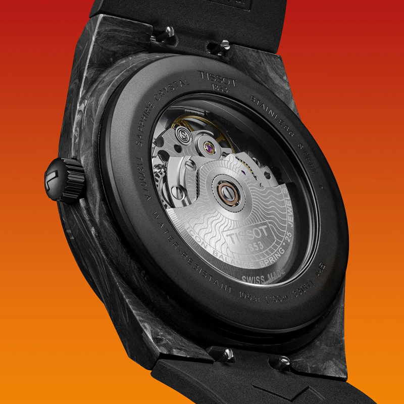 Tissot PRX Powermatic 80 Carbon 40mm watch on a colored background