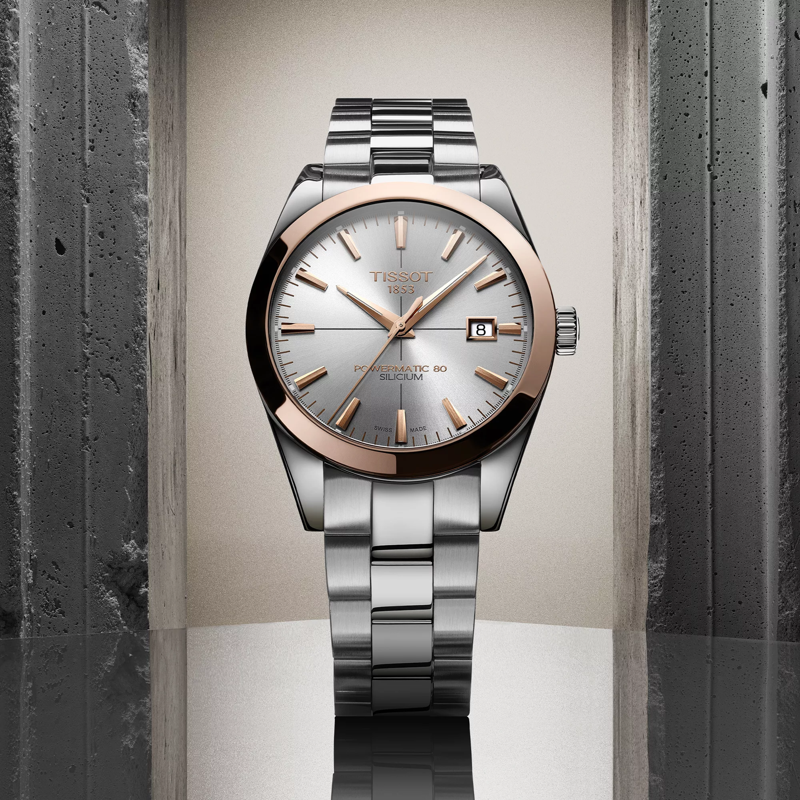 Tissot Gentleman Powermatic 80 Silicium Solid 18K Gold bezel watch on a colored background