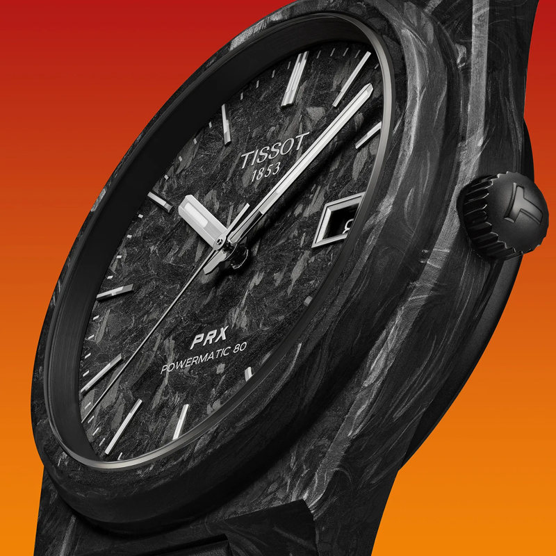 Tissot PRX Powermatic 80 Carbon 40mm watch on a colored background