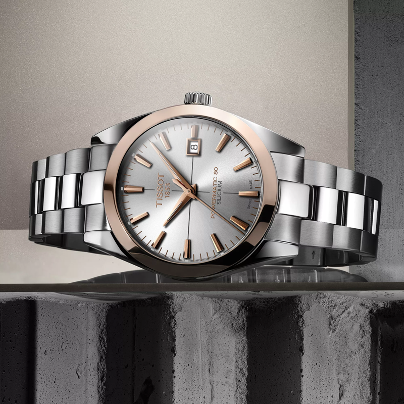 Tissot Gentleman Powermatic 80 Silicium Solid 18K Gold bezel watch on a colored background