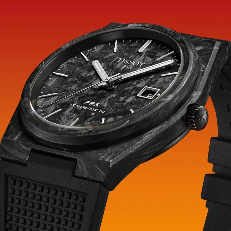 Tissot PRX Powermatic 80 Carbon 40mm watch on a colored background