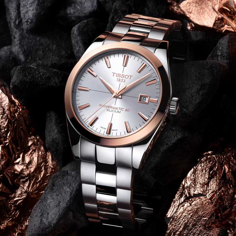 Tissot Gentleman Powermatic 80 Silicium Solid 18K Gold bezel watch on a colored background