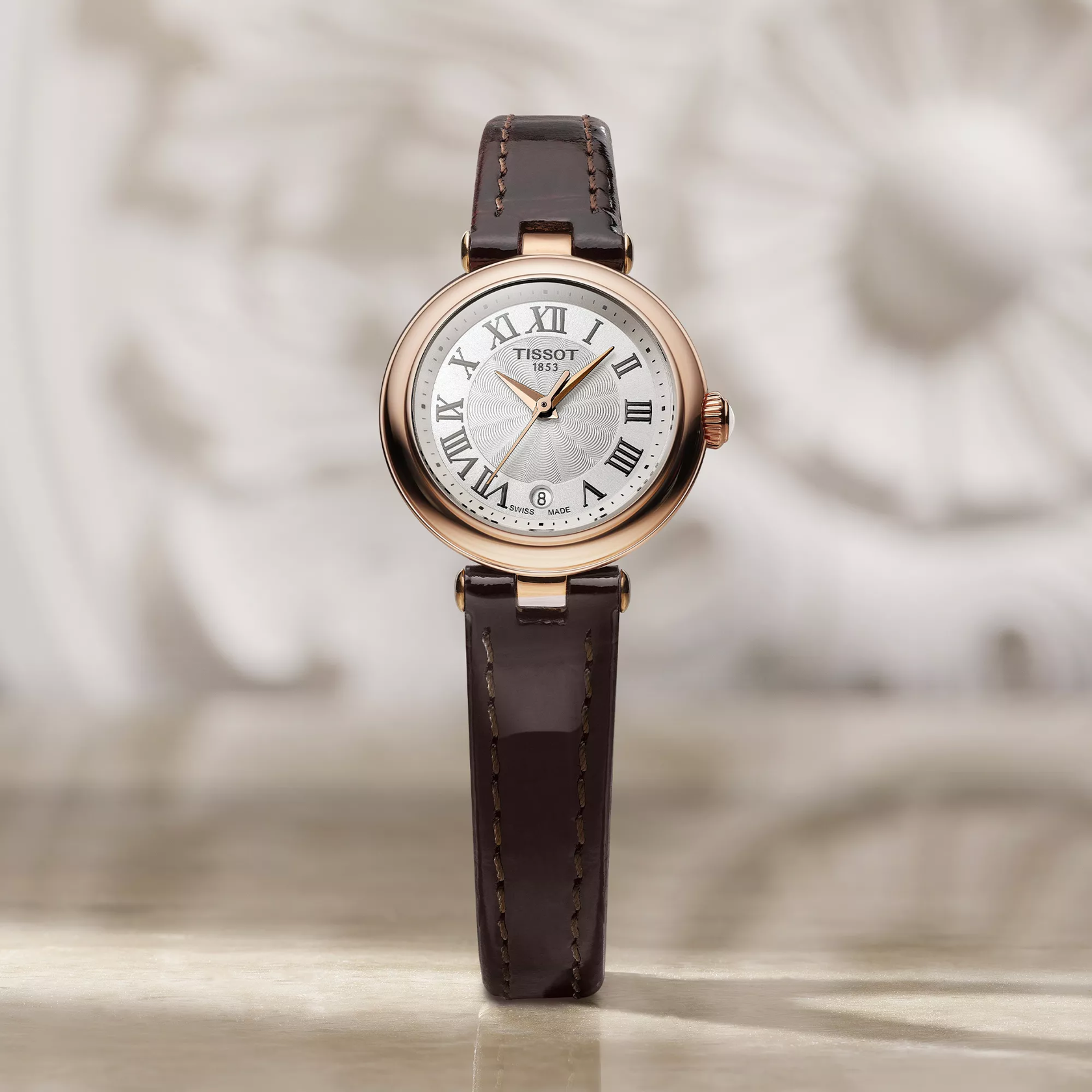 Tissot Bellissima Small 26mm watch on a colored background